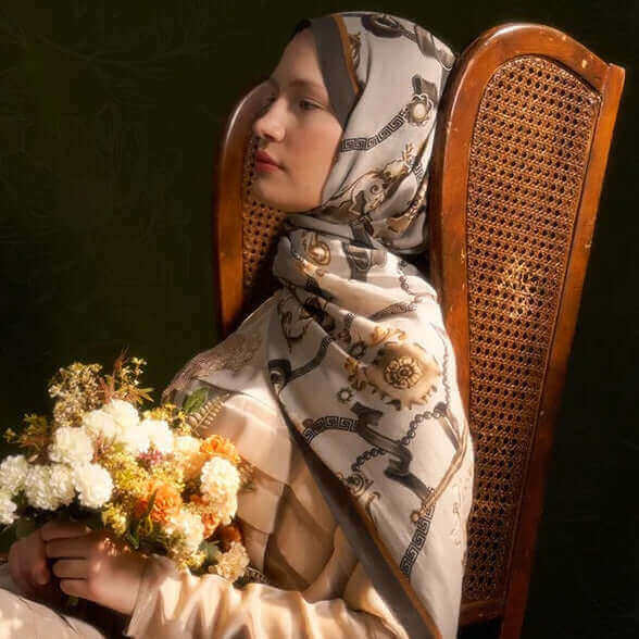 "Bej zemin üzerine zincir ve inci desenli şal ile çiçek buketi tutan kadın, klasik sandalye ve vintage arka plan önünde"