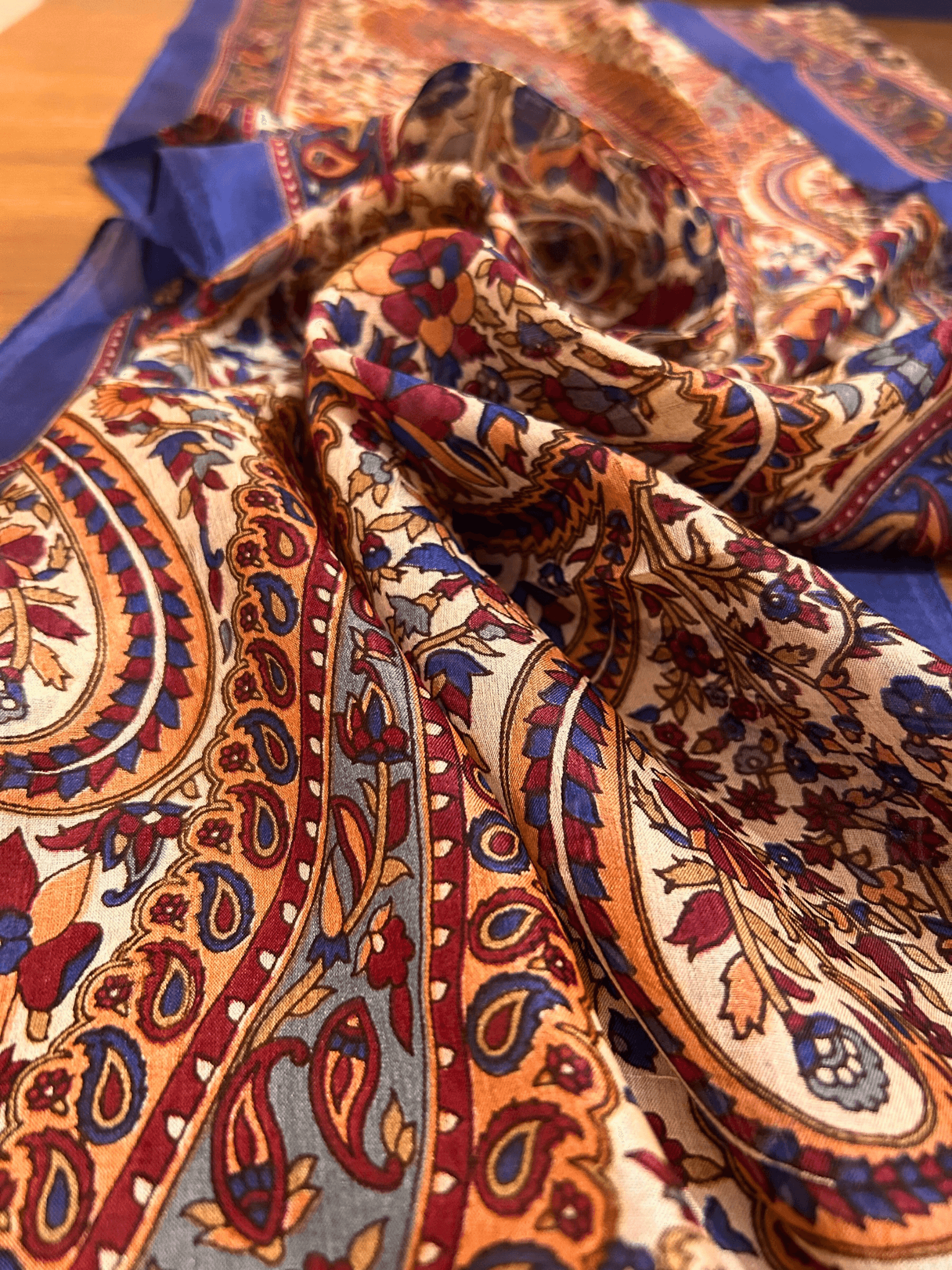 "Lacivert kenarlı, bordo ve bej tonlarında paisley (boteh) desenli Hint ipeği fular – klasik ve zarif motifleriyle sofistike bir stil tamamlayıcısı."
