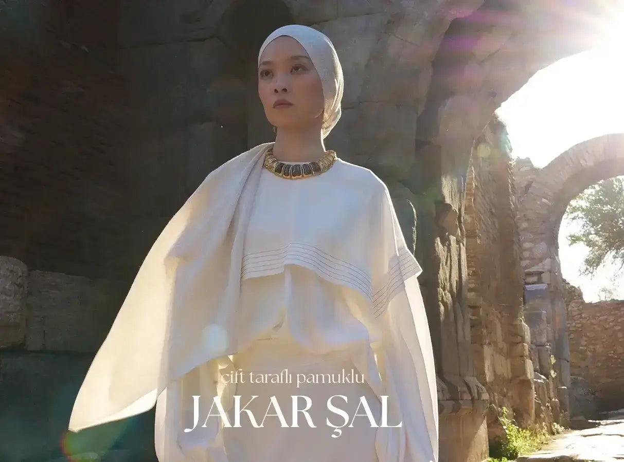 "Tarihi taş yapılar arasında güneş ışığında zarafetle poz veren model, çift taraflı pamuklu jakar şalın doğal ve asil duruşunu vurguluyor."