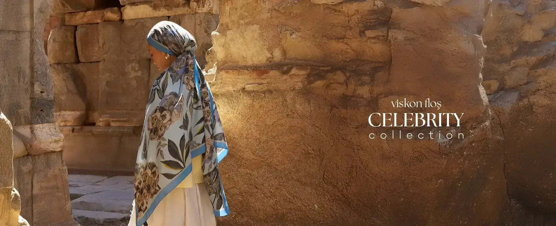 "Celebrity Collection'a ait viskon kumaştan üretilmiş floral desenli flōş şal, tarihi taş duvarlar önünde zarafetle sergileniyor."