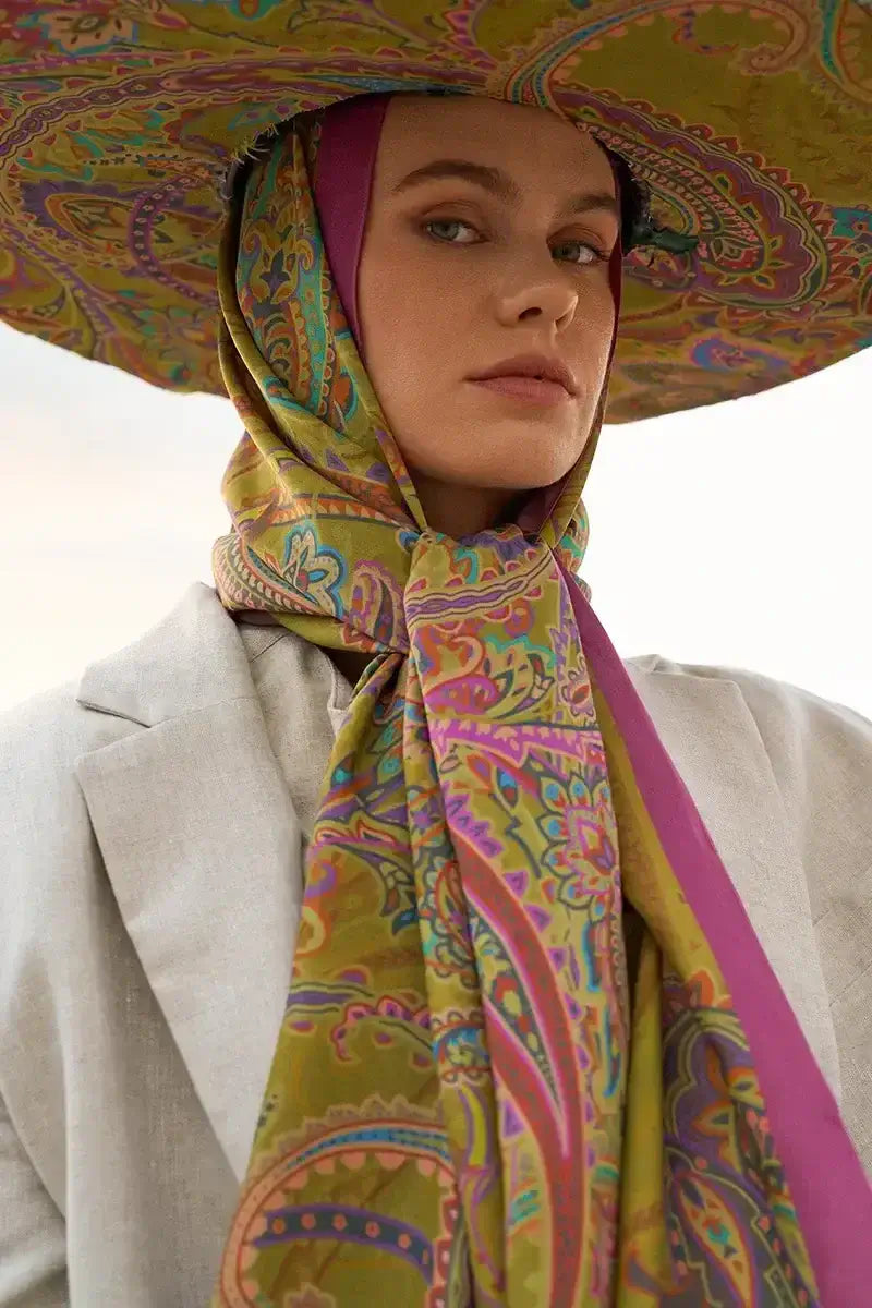 "Renkli etnik desenli fular ve büyük şapka kombiniyle sofistike bir duruş sergileyen model, Iconic Collection’ın sanatsal ruhunu yansıtıyor."
