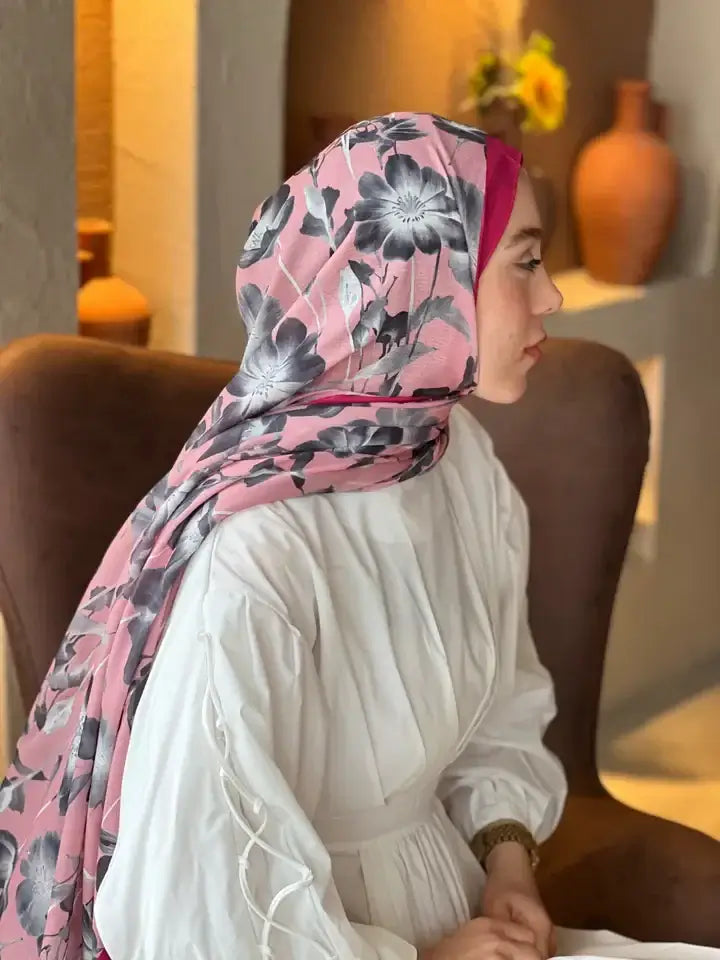"Pembe zemin üzerine siyah çiçek desenli Lina Şal, doğal dokusuyla zarif ve modern bir görünüm sunuyor."
